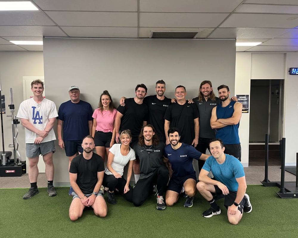 A cheerful group of personal trainers from the State of Fitness studio poses for a photo.