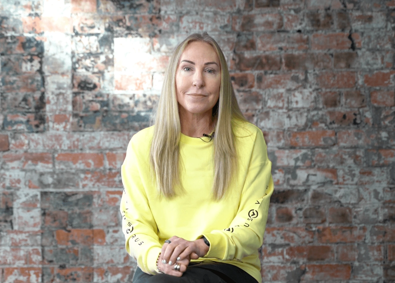 A beautiful woman is wearing a bright yellow sweatshirt, sitting at ease with a calm mind.